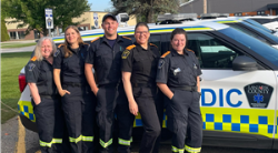 A group of five paramedics stand in uniform