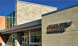 Exterior View of the Fairview Manor entrance of building with blue skies photo